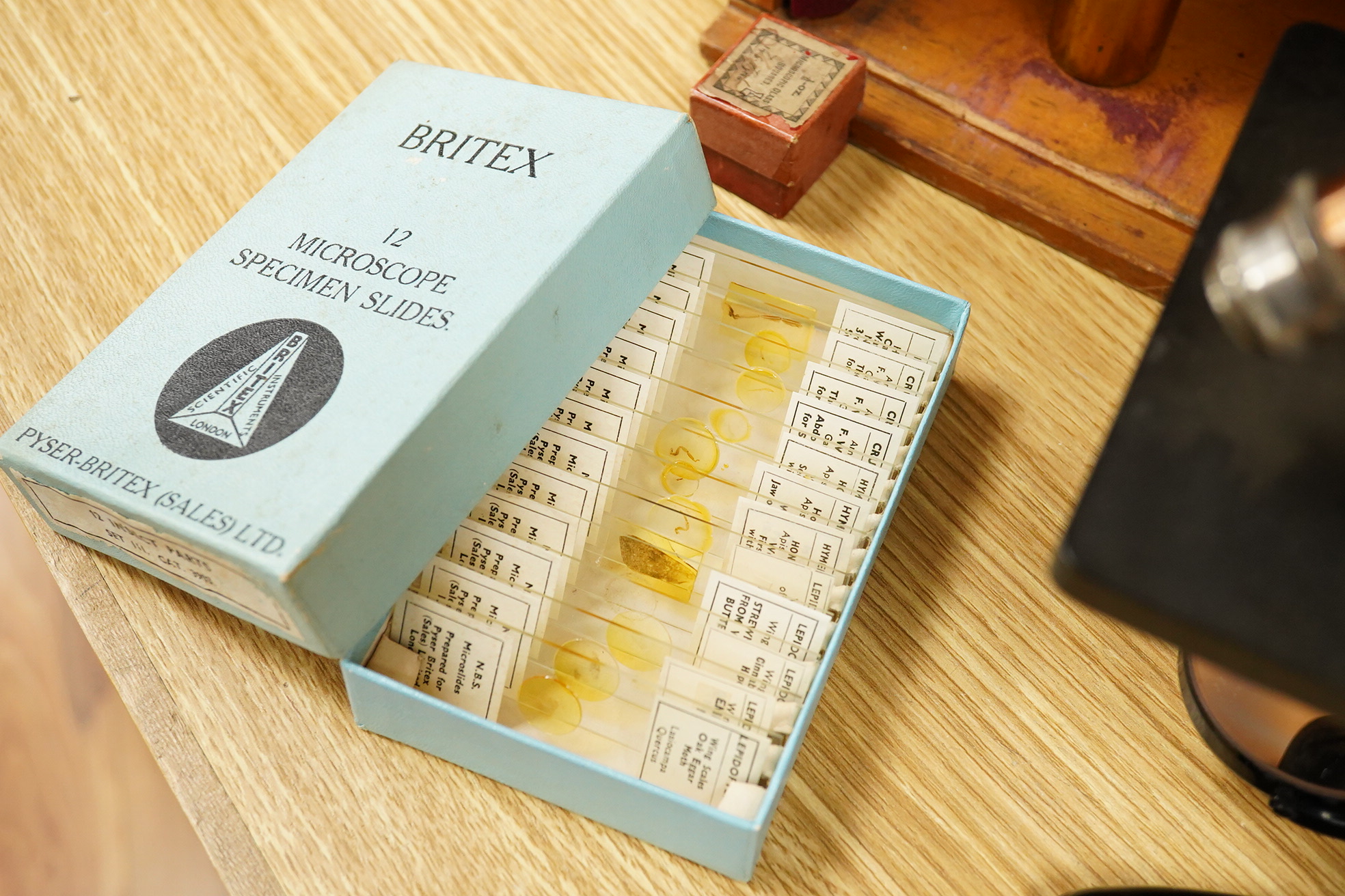 An early 20th century teak cased Ernst Leitz, Wetzlar brass and cast iron monocular microscope, serial no. 268264, with fitted interior to the case and card box of specimen slides, case dimensions; 36cm high, 19cm wide,